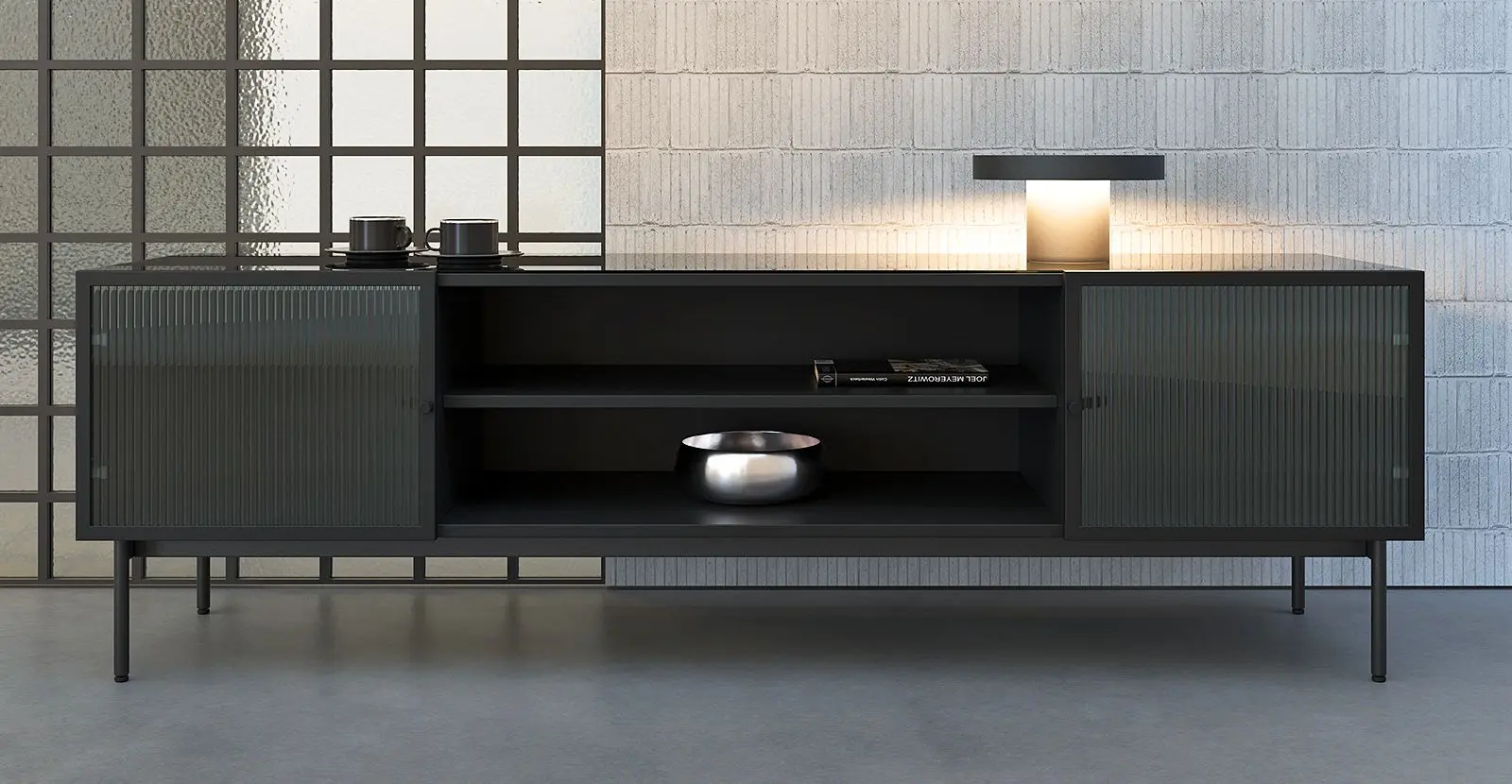 Стильна низька тумба Leon з темного матеріалу з рифленими скляними дверцятами в сучасному інтер’єрі, прикрашена лампою та декоративними предметами